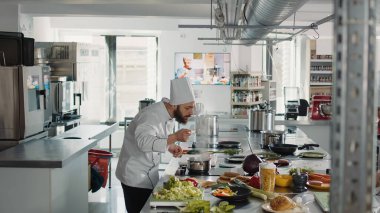 Erkek aşçı fırında lezzetli sosla lezzet testi yapıyor.