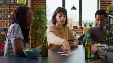 Gençler oturma odasında strateji oyunu oynuyorlar.