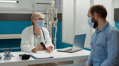 Doktor hasta hastaya ilaç ve tedavi için yardım ediyor.