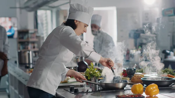 Male cook using frying pan to steam vegetables for gourmet dish —  Fotos de Stock