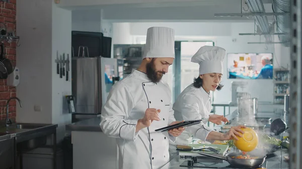 Αρσενικό σεφ μετά από online συνταγή τροφίμων στην οθόνη αφής δισκίο — Φωτογραφία Αρχείου