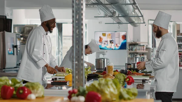 Diverse team of chefs making meal preparations with ingredients