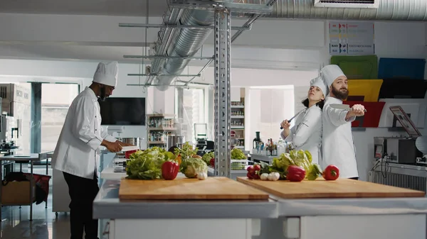 Hombre y mujer cocineros actuando divertido con cuchillos en la cocina —  Fotos de Stock