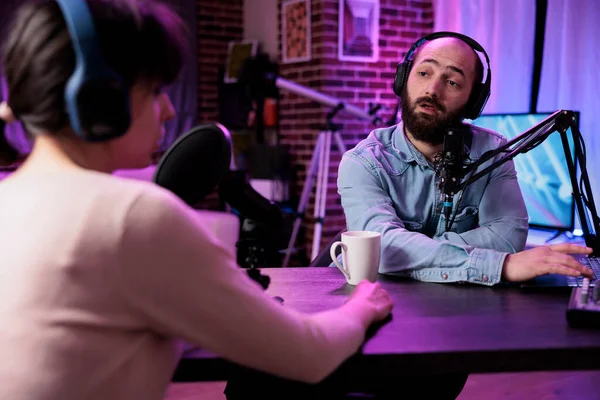 Man and woman streaming podcast content with modern equipment