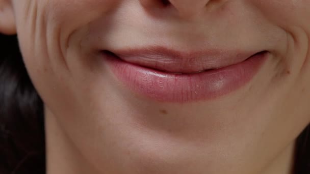 Macro shot of female model smiling and moving lips on camera — Video