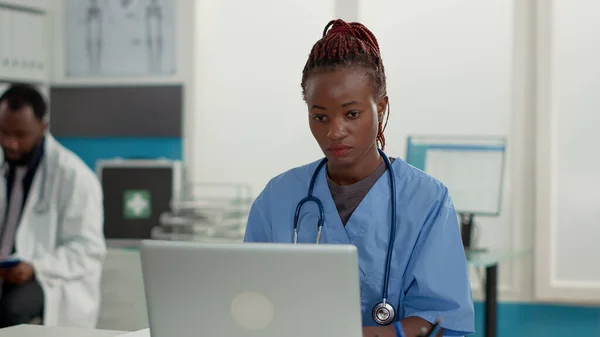 Portret pracownika służby zdrowia korzystającego z laptopa w gabinecie — Zdjęcie stockowe