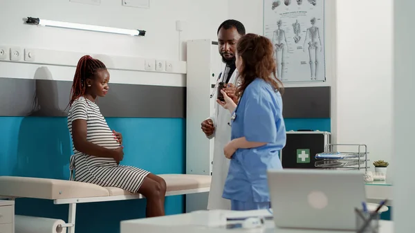 African american doctor giving prescription pills to pregnant patient — Fotografia de Stock