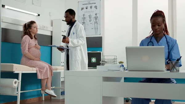 Médico masculino fazendo exame de check-up com paciente expectante — Fotografia de Stock