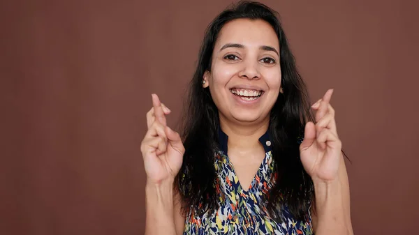 Mulher indiana segurando dedos cruzados para boa sorte no estúdio — Fotografia de Stock
