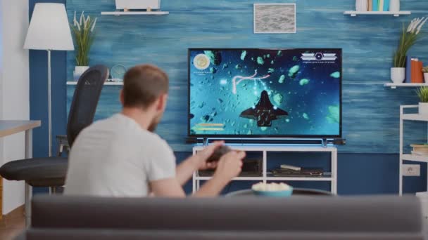 Gamer holding controller celebrando la vittoria nel gioco sparatutto online in prima persona — Video Stock