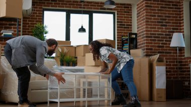 Homeowners couple decorating apartment flat with furniture after moving in