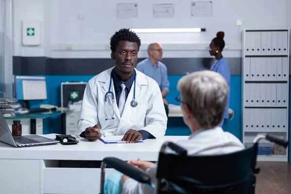 Médecin généraliste parler au patient âgé sur le diagnostic de la maladie dans le cabinet personnel — Photo