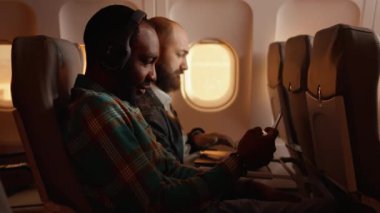 Ticari uçuşlarda hostesle sohbet eden çeşitli yolcular.