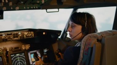 Kadın yardımcı pilot kaptan kabininde kontrol paneli komutu kullanıyor