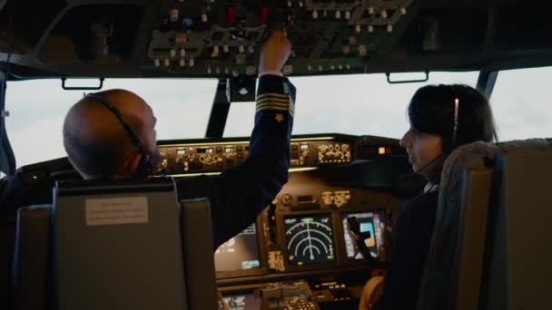 Capitão de avião e copiloto fêmea comutando altitude e nível de longitude — Vídeo de Stock