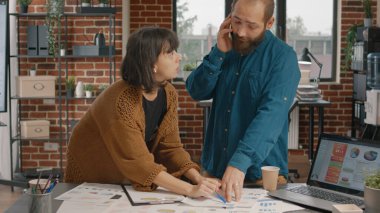 İş projesini planlamak için araştırma belgelerine bakan iş arkadaşları