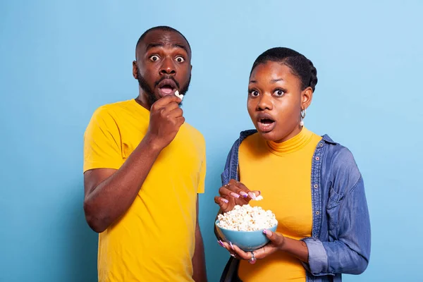 Couple watching scary movie on tv and eating popcorn — Stock Photo, Image