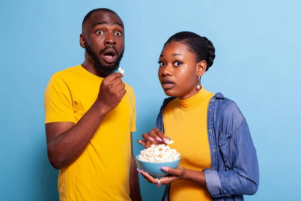 Couple watching horror movie on television and eating popcorn — Stock Photo, Image
