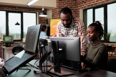 Yazılım şirketinin çalışanları ofis çalışma alanında otururken tasarım fikirleri üretiyor..