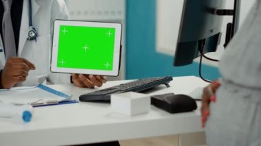 Yatay yeşil ekranlı dijital tableti tutan doktor