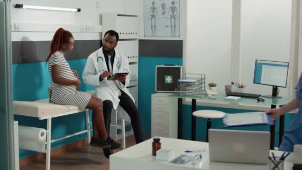 Ludzie spotykający się w gabinecie medycznym, aby porozmawiać o ciąży — Wideo stockowe