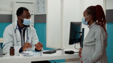 Hamileliği olan Afrikalı Amerikalı doktor ve hasta çocuk doğurmaktan bahsediyor.