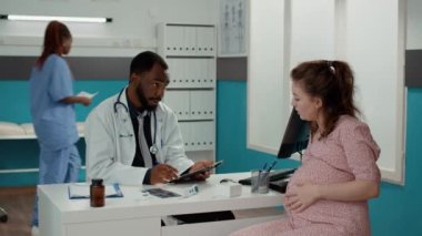 Doğum uzmanı kontrolde dijital tablet hakkında notlar alıyor