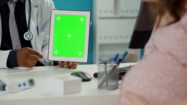 Läkare som håller digital tablett med grön bakgrund — Stockvideo