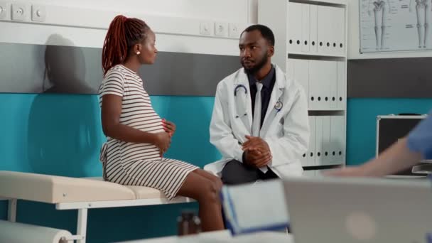 Spotkanie lekarza i kobiety w ciąży w gabinecie, aby porozmawiać o ciąży — Wideo stockowe