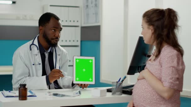 Mężczyzna lekarz pokazuje tabletkę z zielonym ekranem na wyświetlaczu — Wideo stockowe