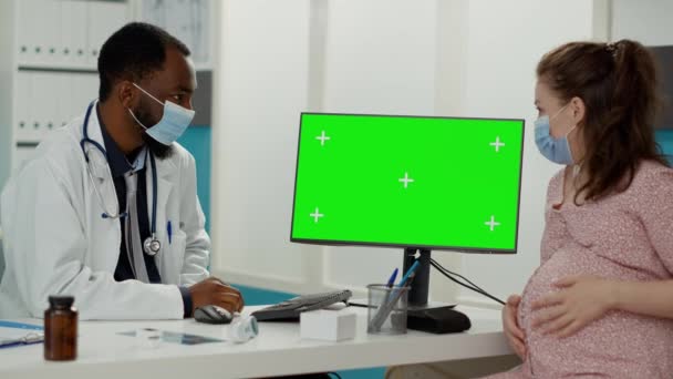 Ludzie z maską twarzy za pomocą komputera z zielonym ekranem — Wideo stockowe