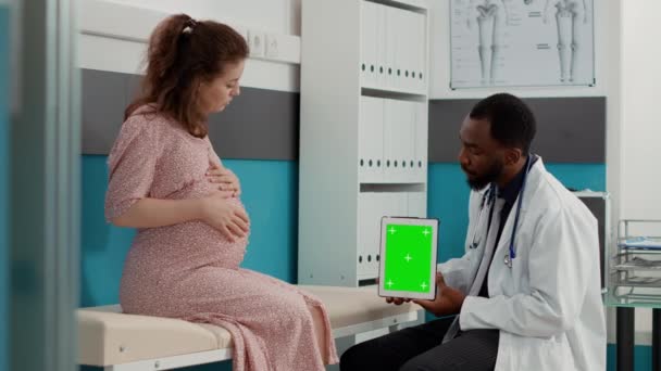 Obstetra sosteniendo pantalla verde en tableta digital en visita de chequeo — Vídeos de Stock