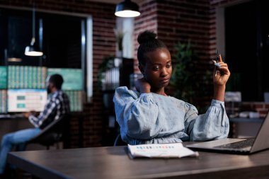 Ofiste otururken boynu ağrıyan bitkin bir şirket çalışanı. Boyun ağrısı ve mesai saatlerinden muzdarip olan yorgun tüccar yatırımcı portföyünü incelerken masa başında oturuyor..