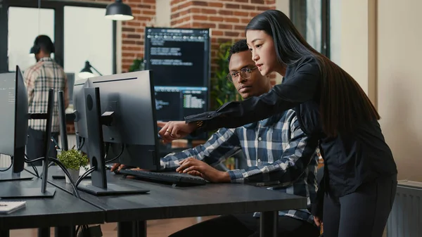 Two Programers Holding Laptop Coding Interface Walking Desk Sitting Talking — Φωτογραφία Αρχείου