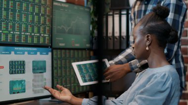 Afro-Amerikan ekibi Forx Yatırım Büyümesi üzerinde çalışıyor, Dijital tablet ve çoklu monitörlere bakıyor. Borsa stratejisini planlamak, finansal ticaret satışlarını geliştirmek için takım çalışması.