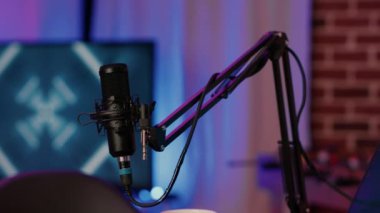 Ev stüdyosundaki çevrimiçi podcast 'te sesi kaydetmek için kullanılan profesyonel mikrofon standına seçici odaklanma. İnternette canlı yayın için kullanılan ses aygıtlarının ayrıntıları.