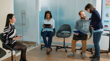 Hamile İK çalışanı ile iş görüşmesine katılan bir adam iş başvurusu toplantısı için CV dosyalarını hazırlıyor. Görev adayı istihdam hakkında tartışmaya hazırlanıyor.