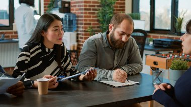 Çok ırklı bir grup işçi işe alım mülakatlarında adaylarla konuşuyor, profesyonel işe alım toplantılarına katılıyor. Kadın başvuru sahibi, insan kaynaklarıyla istihdam hakkında konuşuyor.