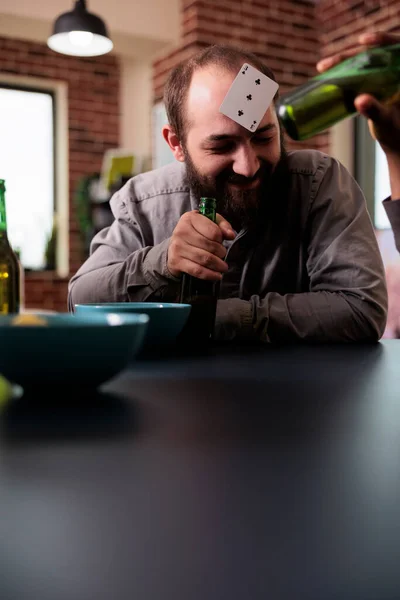 Vrolijke Man Met Plastic Kaart Het Voorhoofd Lachen Met Vrienden — Stockfoto