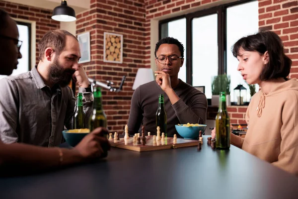 Pensive woman sitting at table in living room while thinking about next  chess move. Stock Photo by DC_Studio