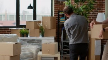 Yeni evdeki mobilyaları ve dekorasyonu boşaltan evli bir çift, kiralık daireye taşındıktan sonra oturma odasını eşyalarla dekore ediyorlar. İpotek kredisiyle ilk konut kredisi almak.