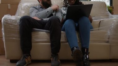 Çok ırklı bir çift dizüstü bilgisayarda ev dekorasyonu ilhamı buluyor. Kiralık daireye taşınmak için online alışveriş yapıyorlar. Yeni başlangıçlar için ev eşyaları ve eşyalar açılıyor..