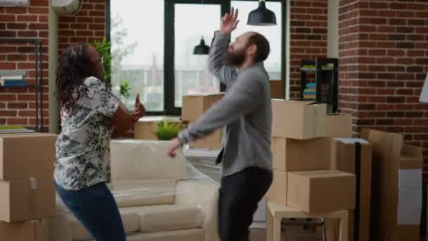 Diversa Pareja Bailando Nuevo Hogar Celebrando Mudarse Juntos Sintiéndose Emocionados — Vídeos de Stock