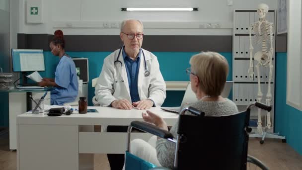 全科医生在医务室咨询患有慢性残疾的妇女 用药物进行检查 残疾及有健康问题的退休人士预约 — 图库视频影像