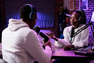 Erkek ve kadın vloggerlar ses üretim ekipmanları kullanarak stüdyoda canlı yayın yapıyorlar. Eğlence amaçlı internet yayınında sosyal medya içeriği oluşturmak için toplanan Mutlu Etkilenenler.