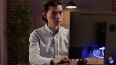 Web sitesinde ticari raporlar üzerinde çalışan Asyalı adam, bilgisayar kullanarak çözüm ve ekonomik plan yaratıyor. Yönetici açılışı için evrak işleri ve e-posta yazma.
