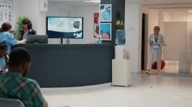 Hastane lobisinde resepsiyonlu bekleme odası. Muayene randevusuna katılmak için bekleyen bir sürü insan var. Kliniğin acil servisinde sağlık muayenesi.