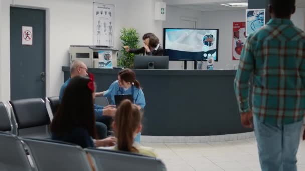 医療機関での医療相談を開始するために列に患者と忙しい病院受付待機エリア 診察予約のための待合室 — ストック動画