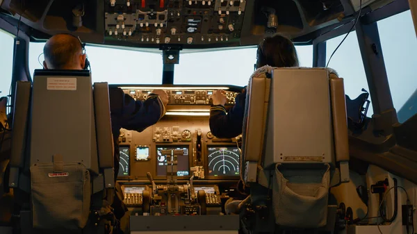 飛行機を飛ぶためにコントロールパネルとコックピットコマンドを使用して ダッシュボード上の平面キャプテンと女性の副操縦士の固定高度 離陸し パワーエンジン 航空会社のサービスを使用する航空ナビゲーション — ストック写真