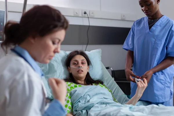 박사는 병원내 설명하는 의료진 튜브를 사용하여 병상에 여인의 모습을 황산염을 — 스톡 사진